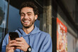 © Drobot Dean - Happy handsome guy smiling and using mobile phone