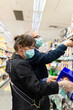 © Sergio Cano - A Caucasian couple shopping at the supermarket during the Covid-19 pandemic. Both are wearing a mask to protect themselves from infection. Their age is about 50 years.
