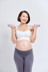 Wall Mural - Pregnant woman is doing exercises at the gym