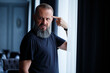 © DSMT - Emotional portrait of an adult gray-haired man with a beard in a black t-shirt
