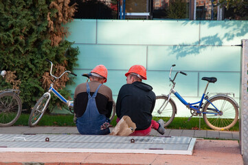 two workers rest after work near the construction site