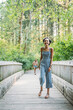 © Inti St. Clair - Teen girls running and laughing on bridge in nature park