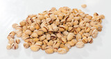 Fototapeta  - Pile of unshelled roasted pistachios on white surface. Concept of healthy and nutritious food