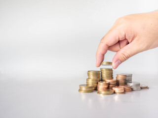 The hand was picking up the money that had been stacked up in layers. White background