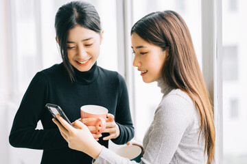 Poster - two asian business women were chatting by the window during recess