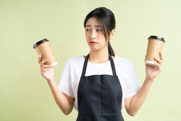 Wall Mural - Asian waitress holding two cups of coffee
