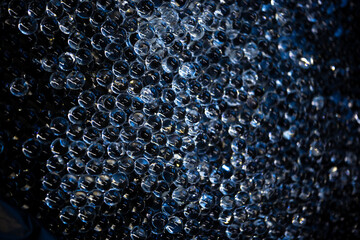 Background of small transparent hydrogel balls illuminated with blue light