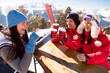 Group Of Friends Enjoying Hot Mulled Wine In Cafe At Ski Resort.