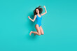 © deagreez - Photo of lovely sweet slim lady model jump high raised fists toothy smile celebrate success trampoline advert season discount sales wear blue swimsuit isolated turquoise color background
