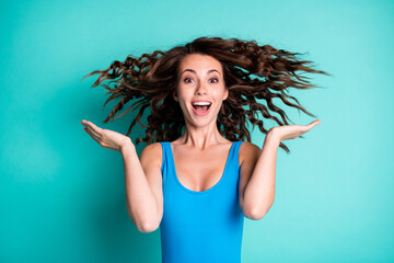 Wall Mural - Portrait of excited shocked girl tourist try leisure resort spa nature hair care treatment impressed haircut fly wear blue bodysuit isolated over teal color background