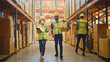 © Gorodenkoff - Male and Female Workers Wearing Hard Hats, Have Discussion and Walking Through Retail Warehouse full of Shelves with Goods in Cardboard Boxes. Working in Logistics and Delivery Center.