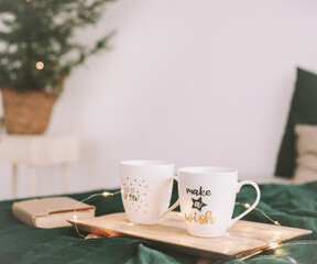 Wall Mural - Cozy bedroom with coffee mugs and book in bed. Christmas still life. Breakfast in bed. Flat lay. Holidays, Christmas concept