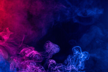 Conceptual image of colorful red and blue color smoke on dark black background.