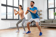 © Syda Productions - sport, fitness, lifestyle and people concept - smiling man and woman exercising and doing squats at home