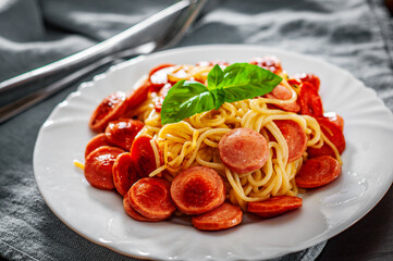 Wall Mural - pasta spaghetti with fried sausage in white plate on table