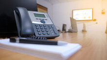 IP Telephone On Working Table In Meeting Room For Communication In Office Center.