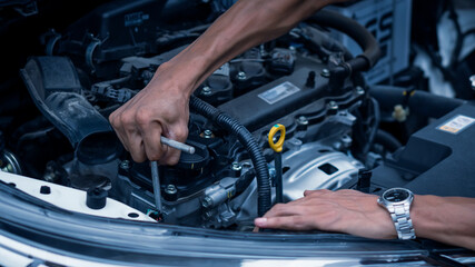 The hand holding an engine mechanic wrench in the auto repair shop