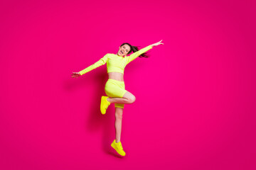 Sticker - Full length body size photo of jumping sportswoman laughing cheerfully wearing stylish sportswear isolated on bright pink color background