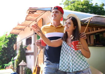 Wall Mural - Happy couple with cups near motorhome. Camping season