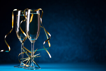 Two glasses of champagne against bokeh lights background. New Year celebration concept