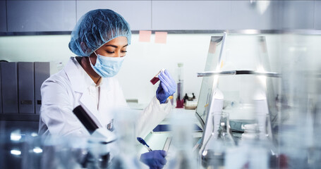 Wall Mural - asian female doctor working on biohazardous samples in laboratory. using microscope