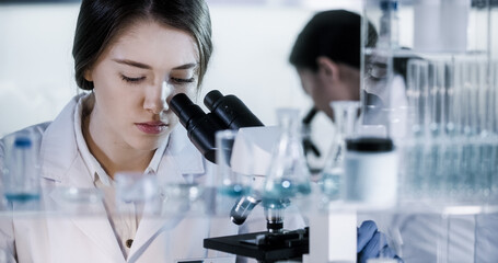 Wall Mural - female doctors testing samples in futuristic laboratory. using microscopes and computer with data