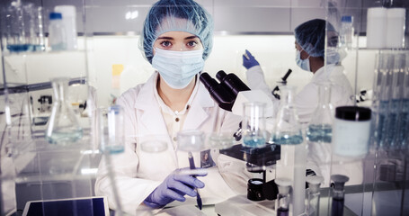 Wall Mural - fe3male doctors in protective workwear studing biohazardous samples. futuristic laboratory interior.