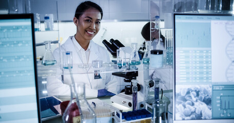 Wall Mural - multi ethnic science team working with microscope and computer. female doctors in futuristic laborat