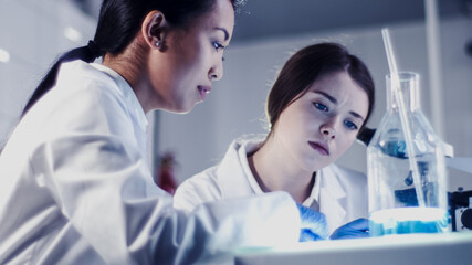 Wall Mural - modern laboratory. female scientists working with microscope. testing biohazardous samples