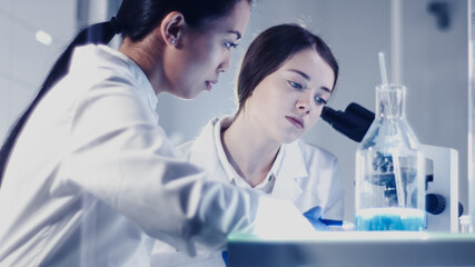 Wall Mural - modern laboratory. female scientists working with microscope. testing biohazardous samples