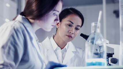 Wall Mural - modern laboratory. female scientists working with microscope. testing biohazardous samples