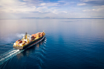 Wall Mural - Aerial view of a loaded cargo container ship traveling over calm ocean towards the next commercial port