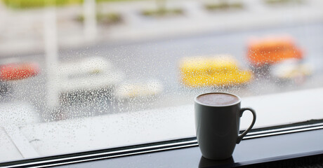 Poster - cup of coffee on windowsill with raindrops on glass