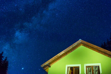 Wall Mural - green house under dark blue night sky with many stars, cosmos milky way background
