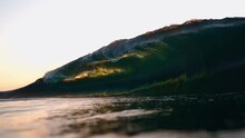 Slow Motion Underwater Massive Turquoise Barrel Wave Breaks Over The Camera On A Sunny Summer Evening. View Of A Crystal Clear Breaking Ocean Wave At Golden Sunset.Cinemagraph Of Up Close Ocean Wave