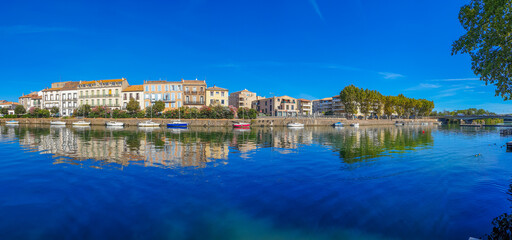 Poster - Panorama view of Herault river at the town Agde with buildings and boats, Languedoc-Roussillon France