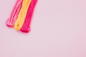 Canvas Print - Top view of colorful yarns isolated on a pink background