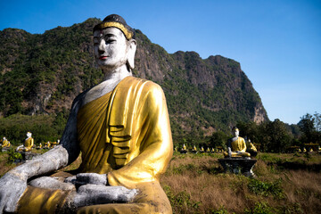 buddha statue in front of Zwegabin Mount and a row of statues