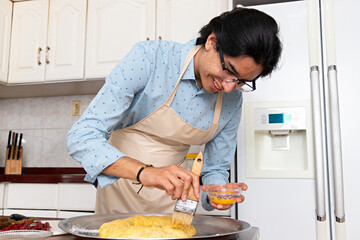 young man in a kitchen, decorating a traditional thread of kings