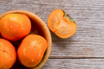  Persimmons fruits in wooden bowl