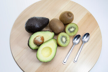 Fresh fruit, kiwi and avocado Placed on a plank floor with 2 spoons