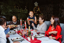 Mexican Family On Christmas Eve Dinner With A Christmas Tree 