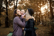 © Med Photo Studio - Young father and mother are kissing their 6 month old baby child girl in the park during the fall walk.