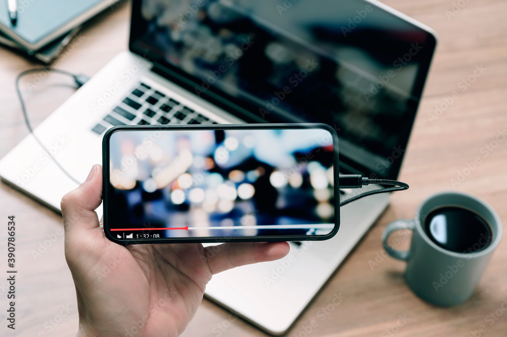 Closeup image of man hand holding smartphone and watching video in ...