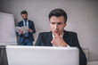 © zinkevych - Attentive man with laptop and colleague with papers behind