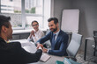 © zinkevych - Two men shaking hands and joyful woman