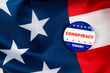 conspiracy theory text on pin isolated on the american flag background to simulate the 2020 presidential election.