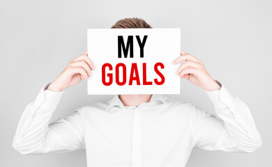 Poster - man covers his face with a white paper with text my goals