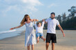 © Siarhei - happy family dad and mom hold baby by the hands, have a rest on a tropical beach. india