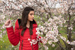 © Michalis Palis - Attractive beautiful lady, dressed in red clothing and plum blossom flowers in spring.